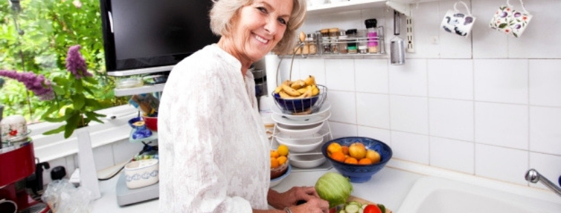 Woman in the kitchen peeling a fruit