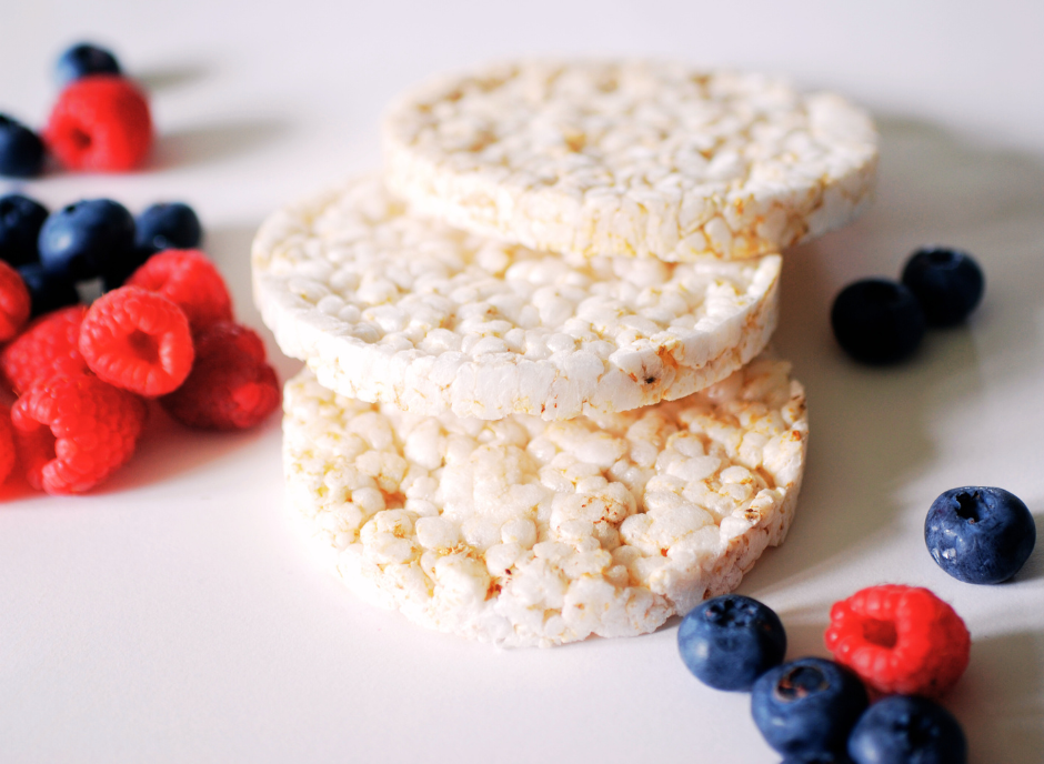 A stack of white rice krispies with blueberries and raspberries.