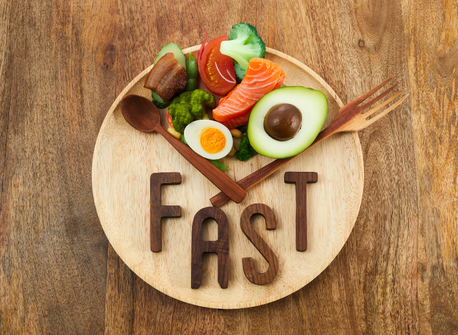 The word fast on a wooden plate with vegetables and a fork.