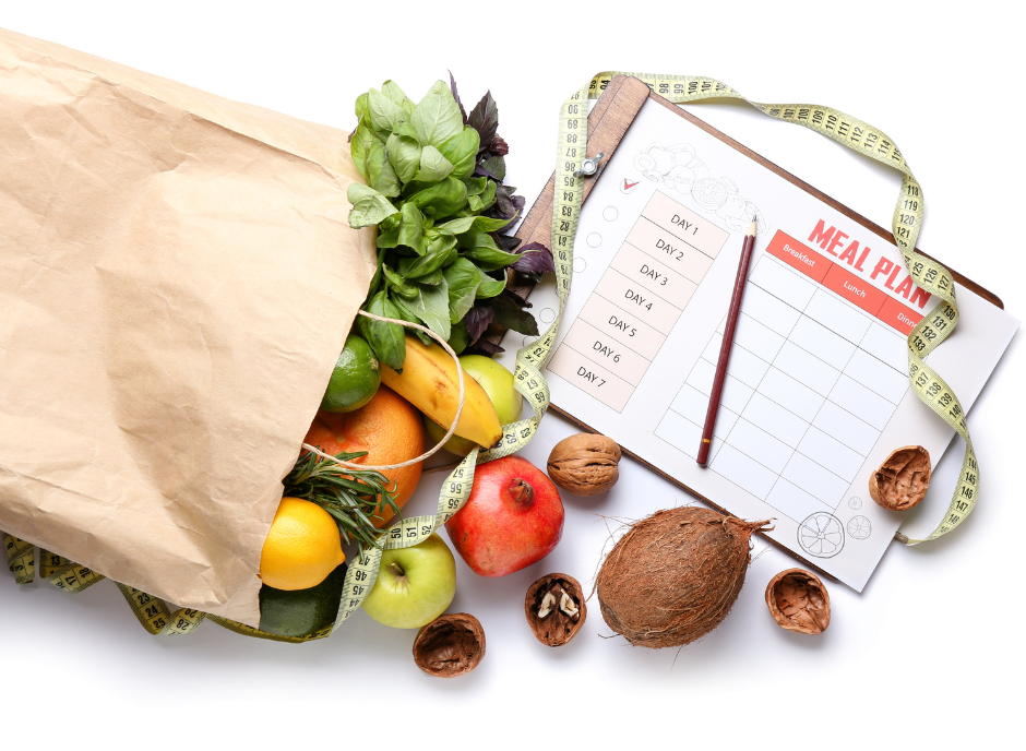 A paper bag filled with fruits and vegetables and a measuring tape.