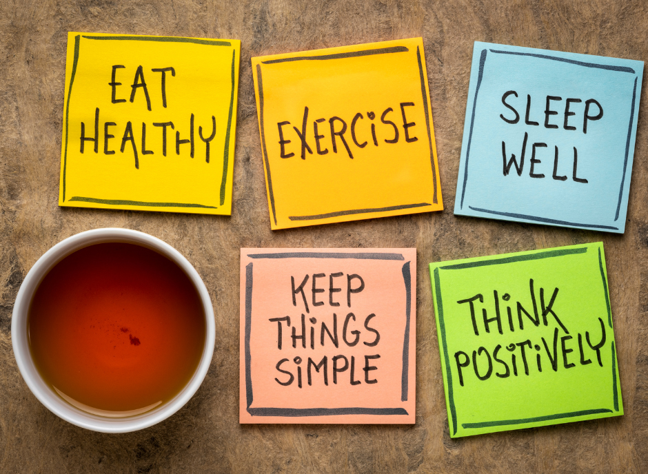Four sticky notes with the words eat exercise well keep things positive.