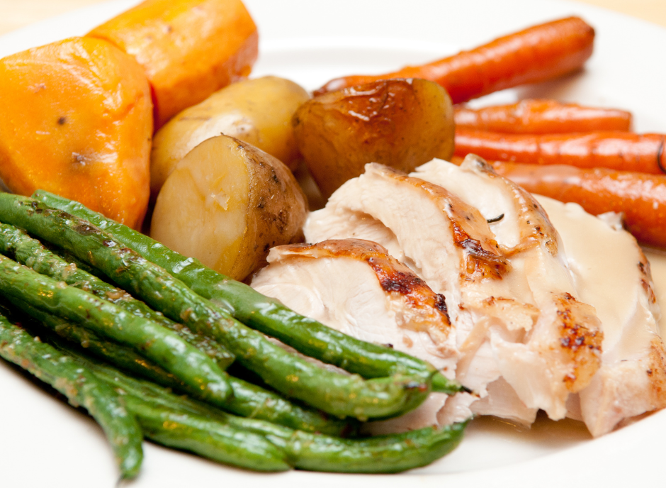A plate of chicken, green beans, potatoes and carrots with fruits to lower creatinine levels incorporated.