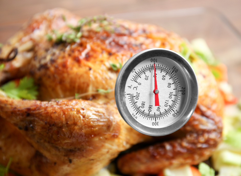 A thermometer is placed on top of a roasted chicken, accompanied by fruits to lower creatinine levels.