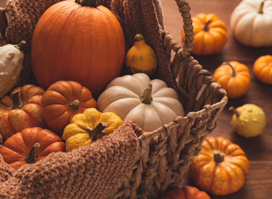 Pumpkins in a basket on a wooden table.