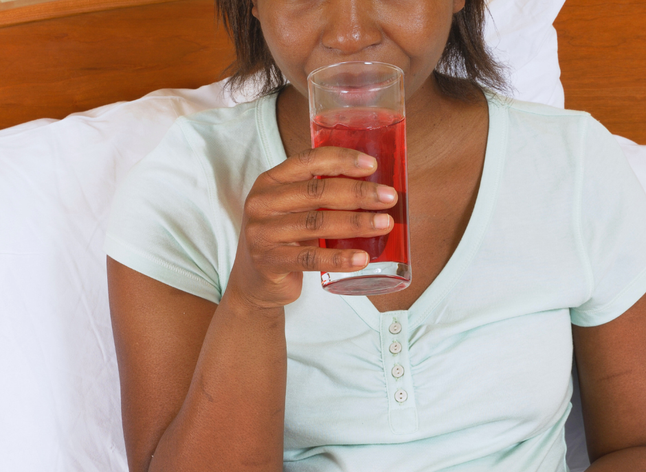 A woman drinking from a glass.