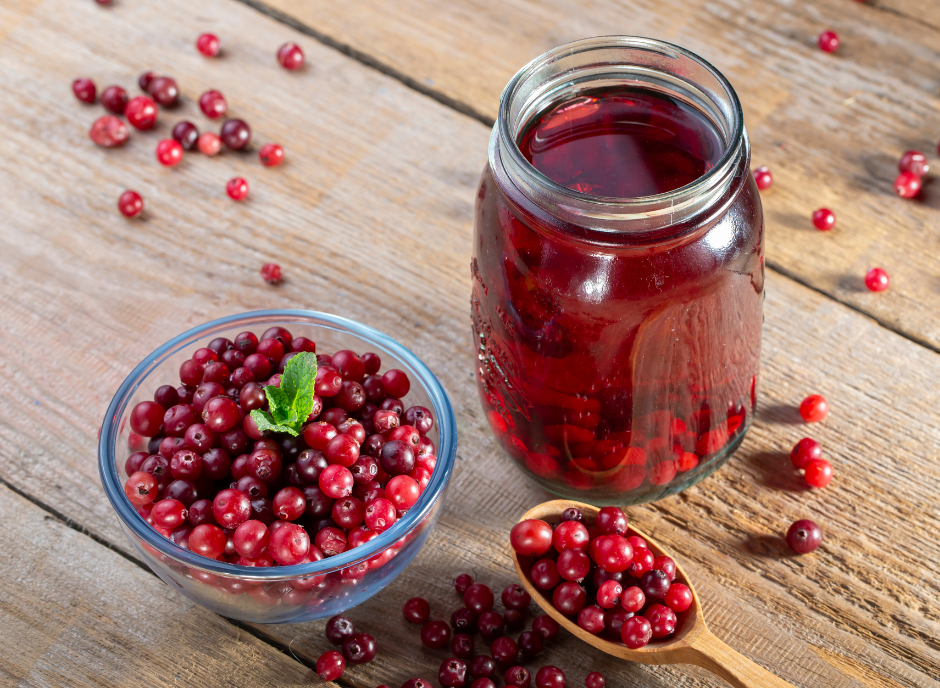 Cranberry juice and cranberries on a wooden table.