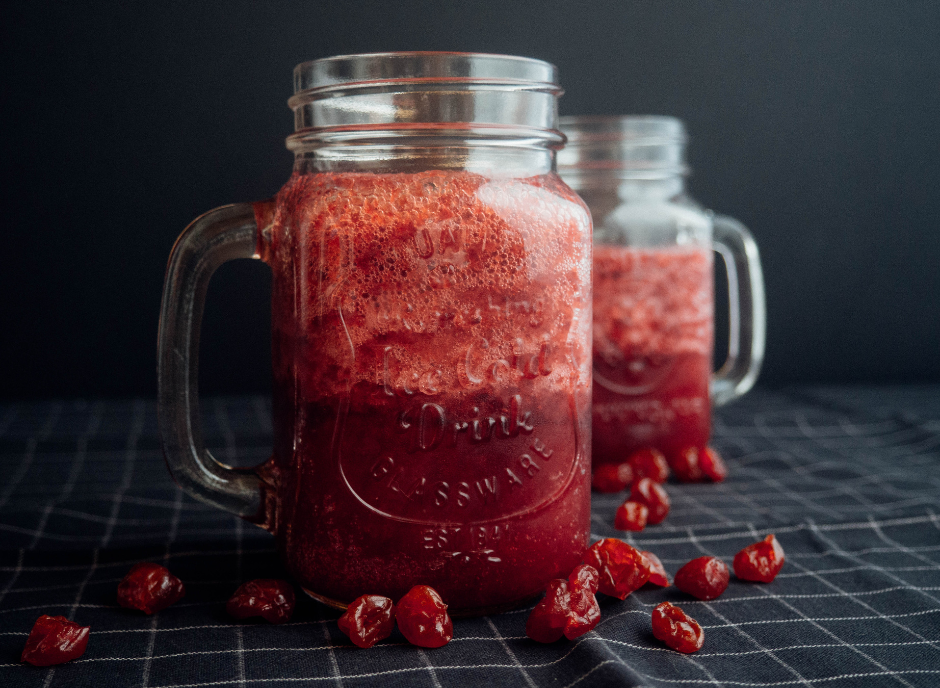 Two mason jars filled with cranberry smoothie.