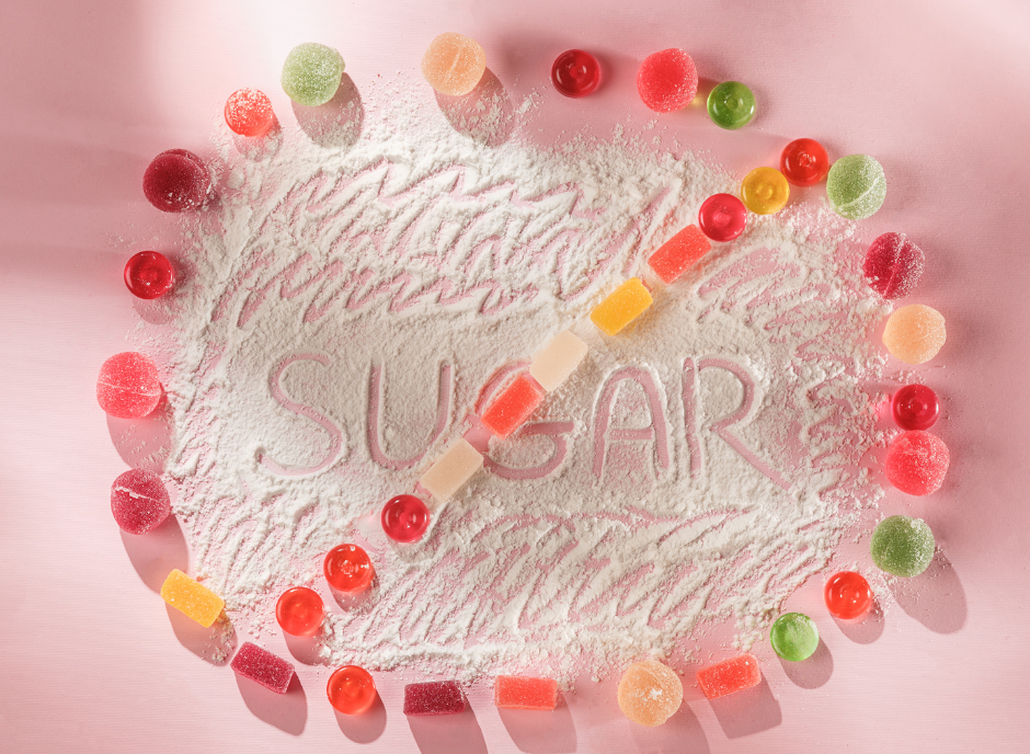The word sugar is surrounded by a variety of sweets.