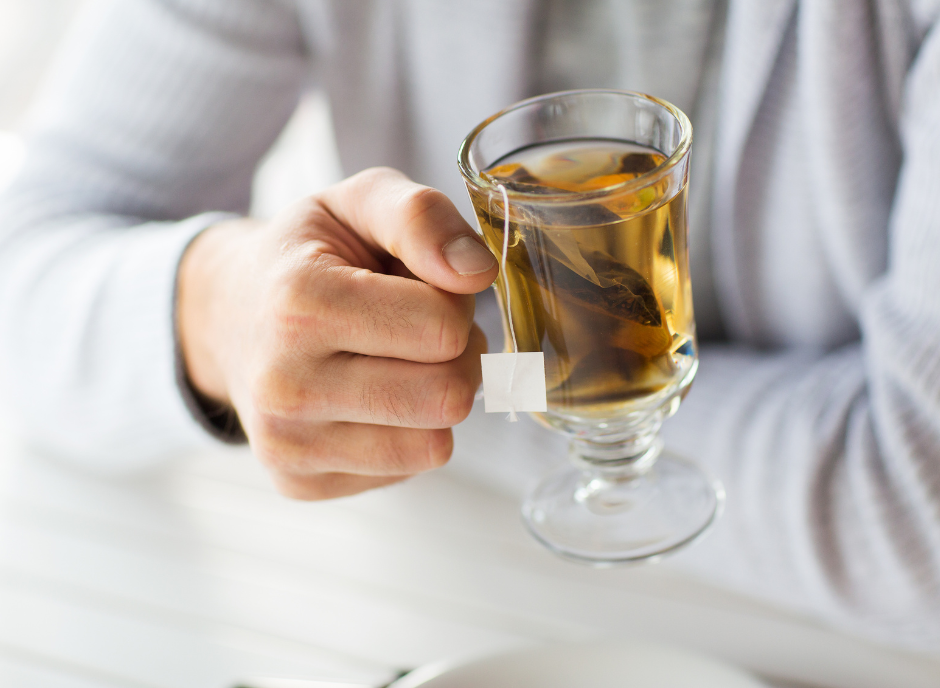 A man is holding a glass of tea, specifically selected for its positive impact on kidney health.