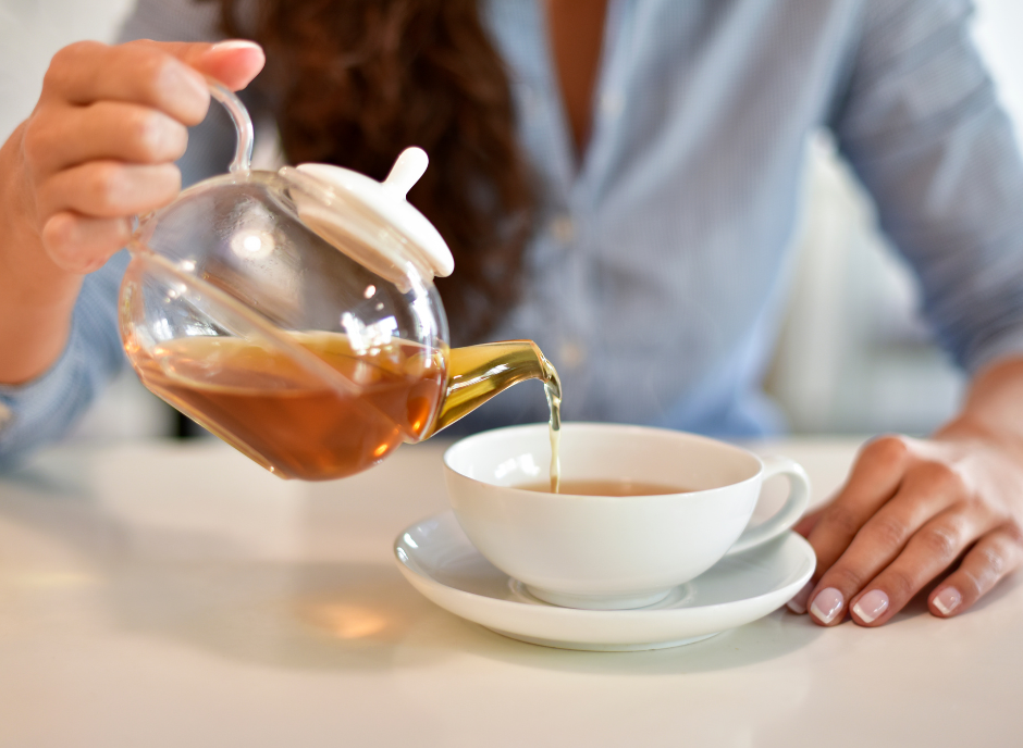 A woman pouring tea, specifically teas good for kidneys, into a cup.