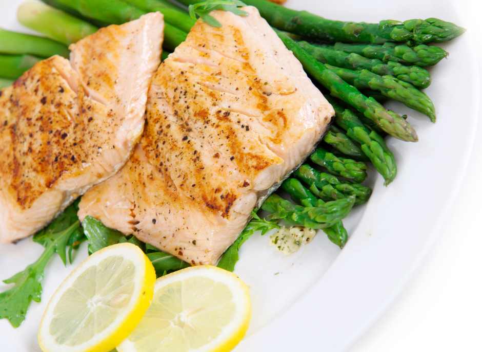 Grilled salmon and asparagus on a white plate.
