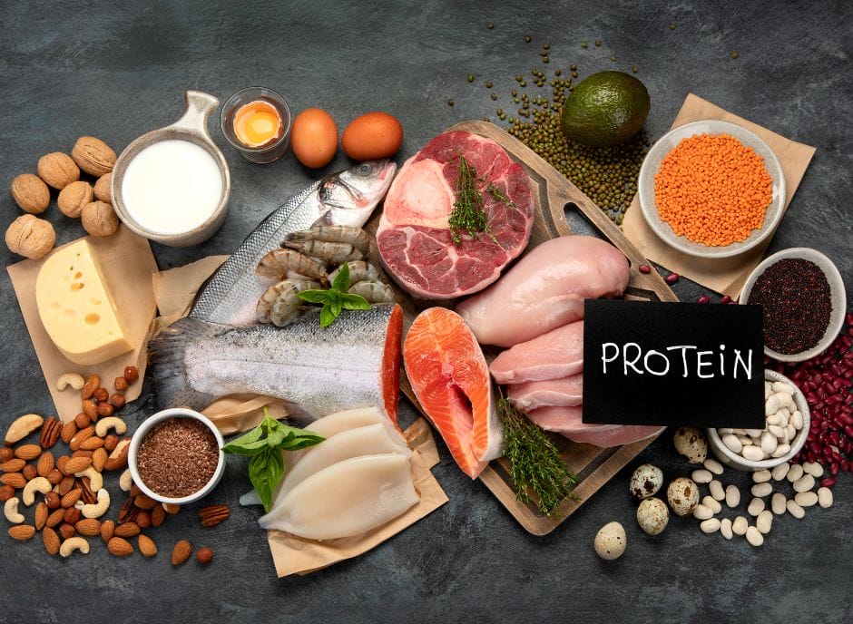 Protein, eggs, nuts, and other foods on a dark background.