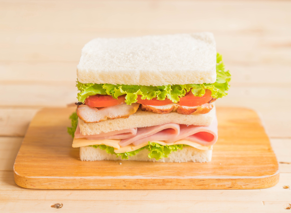 A sandwich on a wooden cutting board.