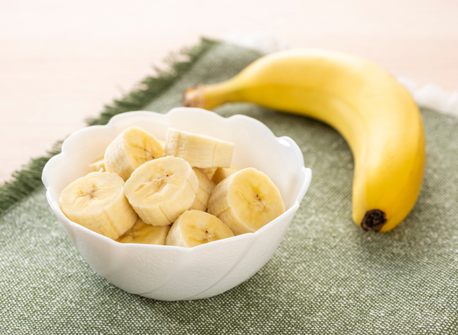 A white bowl with sliced bananas in it.