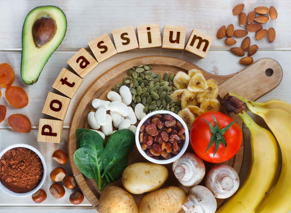 A wooden cutting board with fruits, vegetables, and the word potassium.
