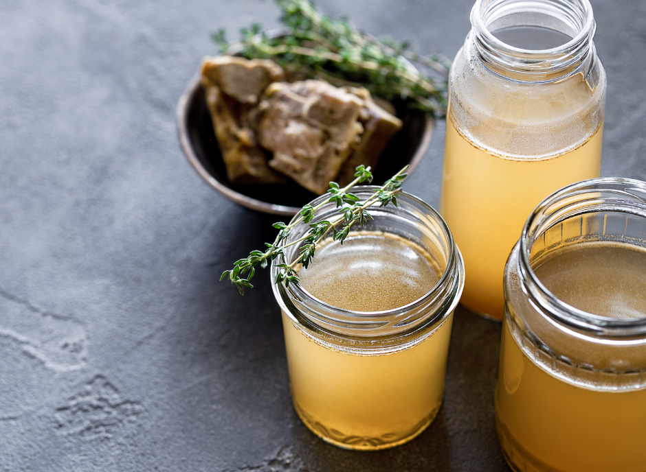 Three jars of honey and thyme on a table.