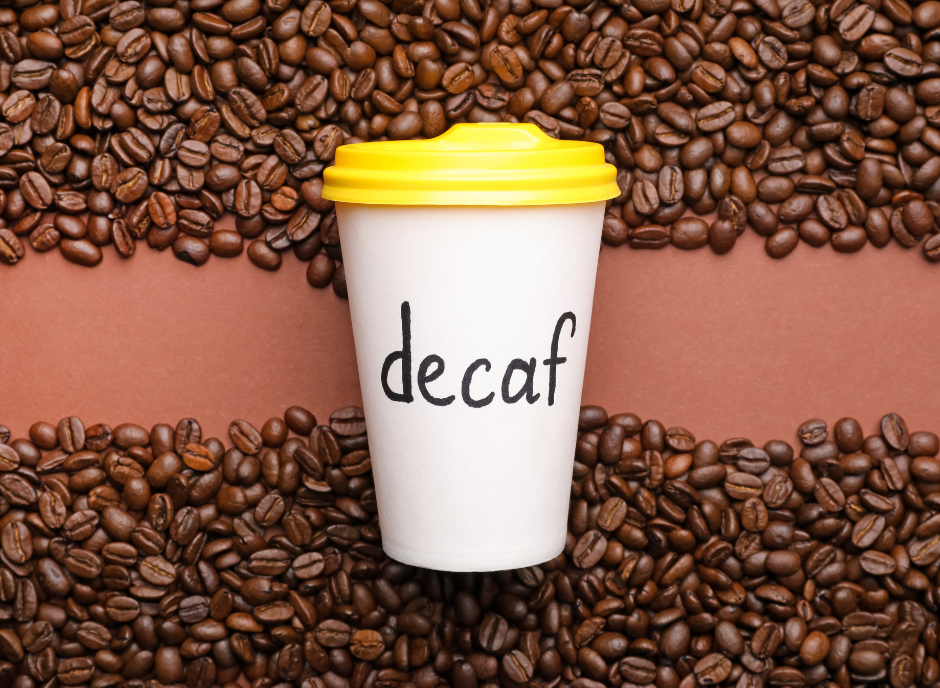 A coffee cup with the word decaf on it surrounded by coffee beans.