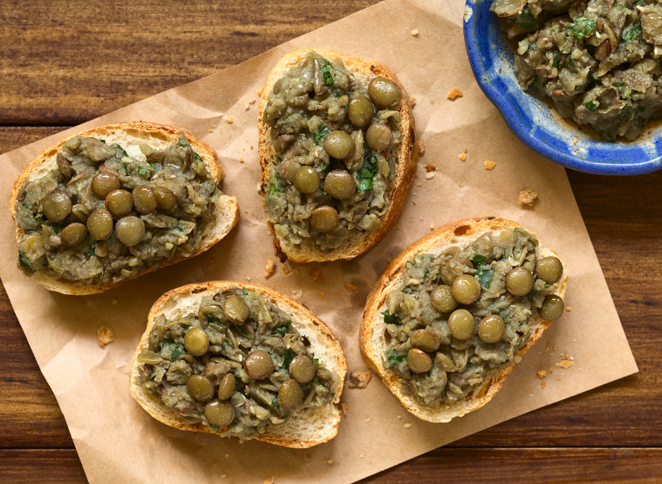 A plate of bread with olives and pesto, perfect for a light meal or appetizer.