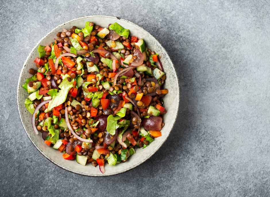 A bowl of kidney-friendly lentil salad on a gray background.