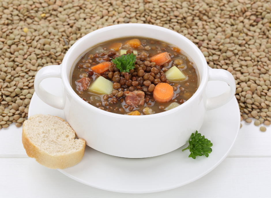 A nourishing bowl of lentil soup served alongside bread and carrots.